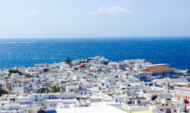 Mykonos şehrinin açık mavi gökyüzünün altında Ege Denizi 'ne bakan beyaz yıkanmış binaları. Cycladic Mimarinin Yüksek Görüntü Fotoğrafçılığı. - Evet. Yüksek kalite fotoğraf