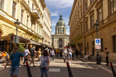 Macaristan 'ın başkenti Budapeşte' de mavi gökyüzü altında ziyaretçiler tarafından çevrelenmiş büyük kubbesi ve ikiz çan kuleleriyle Aziz Stephens Bazilikası. 