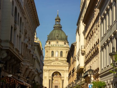 St. Stephens Bazilika Kubbesi ve girişi Budapeşte, Macaristan 'da dar bir sokaktan, açık mavi gökyüzünün altında, 14 Nisan 2024' te çekildi.. 