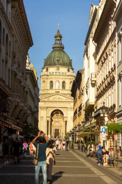 St. Stephens Bazilika Kubbesi ve girişi Budapeşte, Macaristan 'da dar bir sokaktan, açık mavi gökyüzünün altında, 14 Nisan 2024' te çekildi.. 