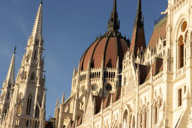 Budapeşte 'deki Macar Parlamentosu binasının ayrıntılı dış görünüşü neo-gotik mimari, sivri kuleler, kemerler ve süslü taş işçiliği sergiliyor. 