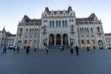 Macaristan Parlamento Binası 'nın Budapeşte' deki ön girişinde, turistler meydanda yürürken, neo-gotik mimari sergilenirken, 14 Nisan 2024 'te fotoğraflandı.. 