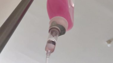 Vitamin sıvısı içeren pembe sıvı damlacıklar.