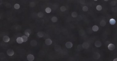 Siyah bokeh arka planı. Siyah arka planda parlak beyaz parıltılar