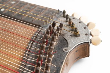 Yüksek açılı, klasik, beyaz arka planda izole edilmiş eski ahşap bir resim. Mekanik ve akort iğnelerinin ayrıntıları. Tozlu ve çizilmiş müzik aleti