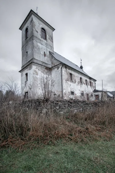 Vertical shot of old Church of Saint John of Nepomuk falling apart on a warm cloudy day of winter. Mysterious, atmospheric, haunted place