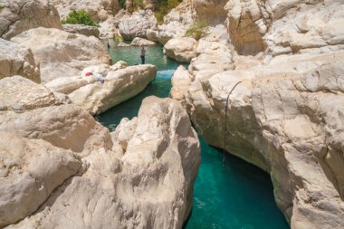 Wadi Bani Khalid, Umman - 04.05.2018: Wadi Bani Khalid, Umman 'da turkuaz sularla kaplı küçük, beyaz taş vadi. Arap çölünde güzel doğal yüzme havuzu
