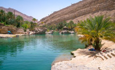 Wadi Bani Khalid, Umman - 04.05.2018: Wadi Bani Khalid 'de büyük bir turkuaz havuzu, Umman. Arap çölünde çok güzel doğal bir yüzme havuzu. Meşhur vaha eğlence için kullanılır.