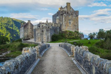 Stone bridge of Eilean Donan castle in early morning. Medieval Scottish castle by the water on a nice summer day. Castle in Scottish highlands. Cultural heritage of Scotland clipart
