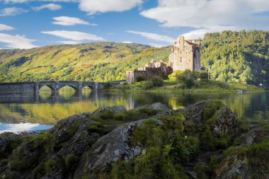 Sabahın erken saatlerinde Eilean Donan kalesinde. Ortaçağ İskoç kalesi güzel bir yaz gününde suya yansıyor. İskoçya 'daki şato. İskoçya 'nın Kültür Mirası