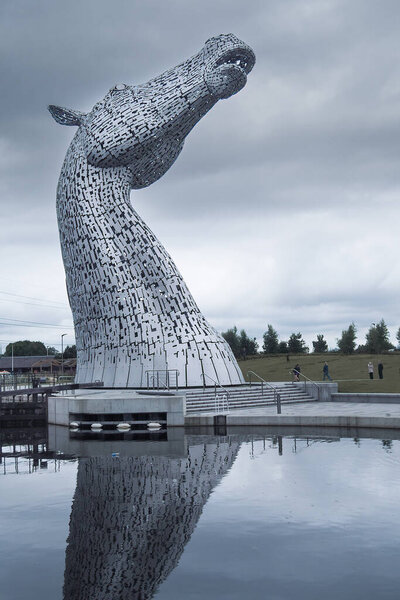 Grangemouth, Scotland - 08.25.2016: Giant metal Kelpies sculptures on a cold and cloudy day. Famous tourist attraction in Scotland. Giant horses statues