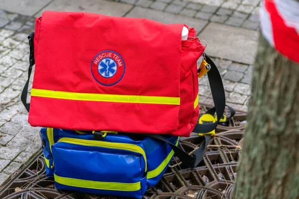 Detail shot of red medical rescue bag with yellow reflective strip in the city street. Medic equipment during outdoor city event