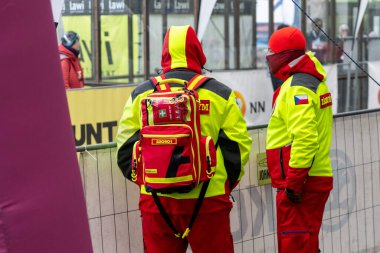 Ostrava, Çek Cumhuriyeti - 02.04.2023: Kentteki yarışı gözden kaçıran parlak yeşil yansıtıcı yelekli iki erkek sağlık görevlisi. Zararsız kış yarışı