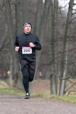 Ostrava, Çek Cumhuriyeti - 02.04.2023: Erkek koşucuların kış amatör koşu yarışı sırasında spor giyim yarışlarında dikey çekimleri. Soğuk kış günlerinde yarışma düzenleriz. Zararsız kış koşusu
