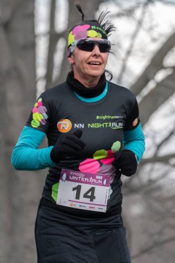 Ostrava, Çek Cumhuriyeti - 02.04.2023: Kış amatör koşu yarışı sırasında bayan koşucuların dikey atımları. Soğuk kış günlerinde yarışma düzenleriz. Zararsız kış koşusu