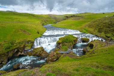 Vahşi nehir İzlanda 'daki yeşil arazide akar. Laugavegur 'dan Skoga nehri ünlü Skogafoss şelalesinin hemen üstünde.