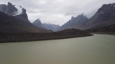 Kanada, Nunavut 'taki Baffin Adası' nın uzak kutup çöllerindeki Zirve Gölü Panoraması. Akshayuk, Auyuittuq Ulusal Parkı 'nda yürüyüş yaptı. Kutup sonbaharının bulutlu bir günü. Mt. Breidablik ve Thor Dağı.