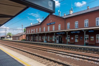 Navsi, Çek Cumhuriyeti - 06.17.2023: Güzel bir yaz gününde tren rayları ve tuğla istasyon binası olan boş tren istasyonu. Trenle yolculuk.
