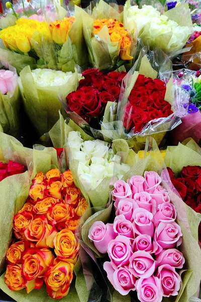 stock image Rose bouquets of pink, orange, red, yellow, white bright colors in flower shop or florist store floral background close up vertical photo. Fresh flower buds top view. Design template with copy space.