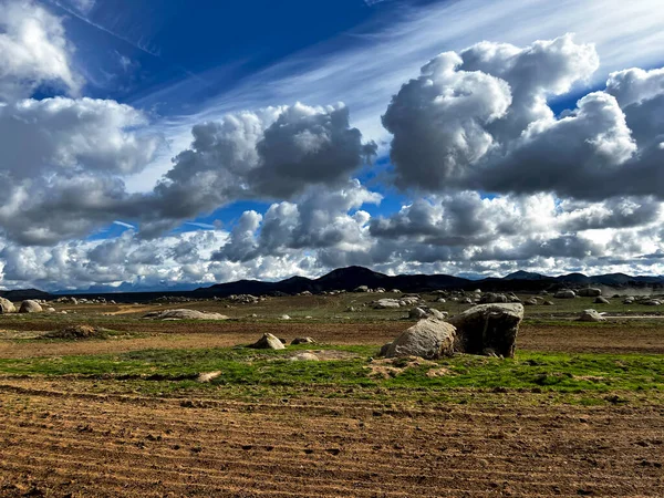 Open land, with beautiful clouds, mountains in the background