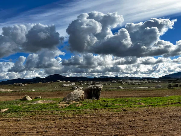 Open land, with beautiful clouds, mountains in the background