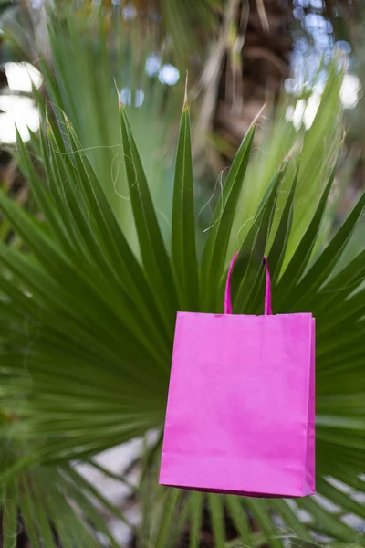 ヤシの木の上にピンクの明るい紙の袋を閉じます モックアップ — ストック写真