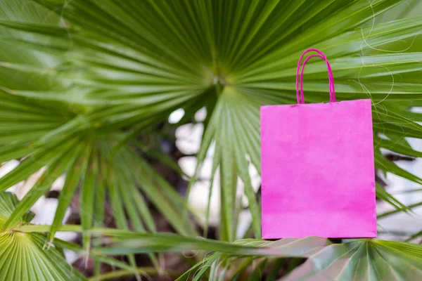 ヤシの葉にピンクの明るい紙の袋 モックアップ — ストック写真