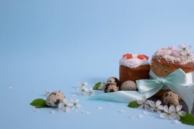 Hediye kurdelesiyle bağlanmış Paskalya pastaları. Mavi arkaplanda Paskalya dekoru.