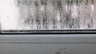 Glass with condensation. Water drops flow down the glass of window. Motion of the camera. 4k footage