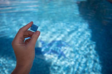 Yüzme havuzunun zemininden küçük fayanslar tutarak. Havuzun alt kapağından döşeme