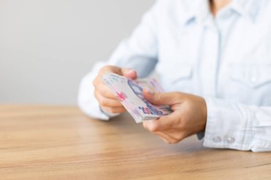 Woman holding Ukrainian 200 bill banknotes. Count Ukrainian money.