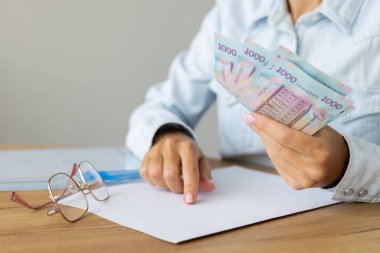 Ukraynalı elinde 1000 banknot tutan bir kadın. Ukrayna parası say.