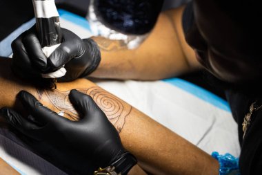 Dövme sanatçısı işine odaklanmış. Yakın çekim.