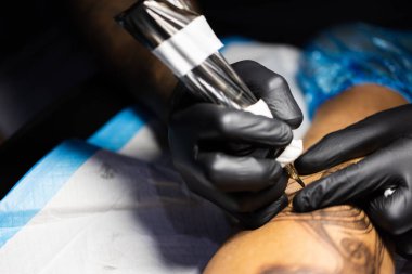 Dövmecinin elindeki dövme makinesi. Yakın çekim..