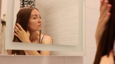 Islak saçlara doğal yağ süren bir kadın. Evde saç bakımı. Tam HD görüntüler