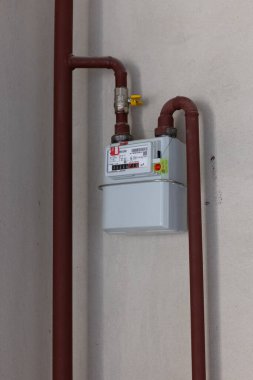 Gaz boruları ile beyaz kapalı duvar gaz sayacı