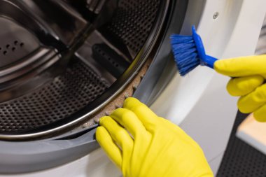  Ellerini koruyucu eldivenlerle fırçayla temizleyip küflü çamaşır makinesine sok.