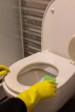 Sünger temizleme kabı olan sarı lastik eldivenli eller.. 