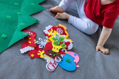 Oyuncak Noel ağacı olan küçük bir çocuk. Çocuklar için eğitici oyunlar