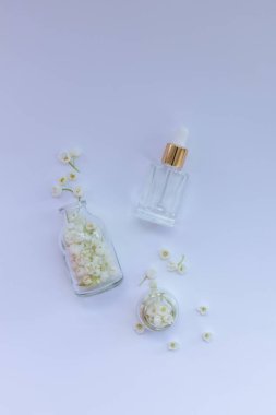 Vadideki cam zambak şişeleri taze çiçeklerle birlikte gerekli yağ. Düz yatıyordu