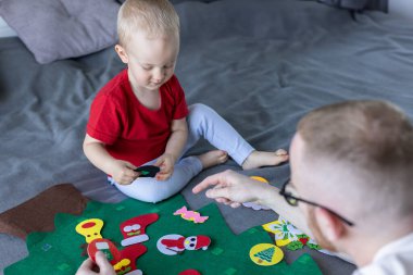 Gülümseyen küçük çocuk babasıyla birlikte Noel ağacı süslüyordu.. . 