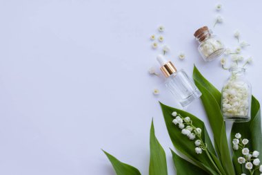 Cam bir şişe vadi zambağı taze çiçeklerle birlikte gerekli yağ. Düz yatıyordu