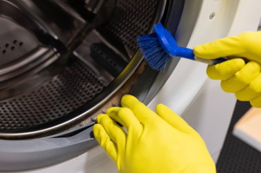  Ellerini koruyucu eldivenlerle fırçayla temizleyip küflü çamaşır makinesine sok.