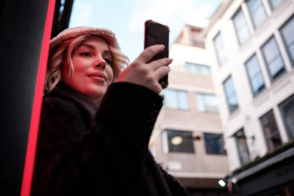 Young Woman Standing Neon Light She Using Smart Phone She — Foto de Stock