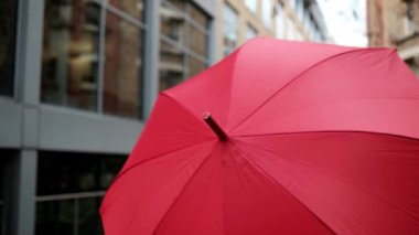 Kırmızı şemsiyeli kadın kameranın önünde yürüyor. Soğuk bir kış günü ve o Londra 'da bir sokakta..