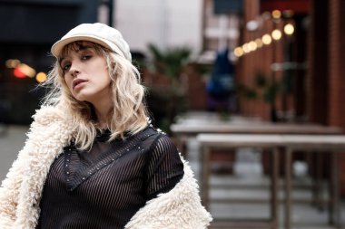 Ciddi bir genç model Londra 'da bir akşam saatinde kameraya bakıyor. Ruh hali portresi, kış titreşimleri.