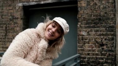 Londra 'da eski bir yapının önünde poz veren alternatif bir kadın model. Soğuk bir kış gününde tırabzana yaslanıyor..