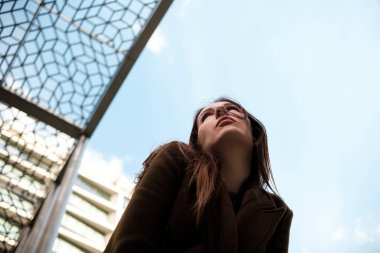 Binalar arasında poz veren beyaz kadın portresi. Ruh hali portresi, vesikalık..