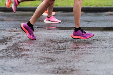 Londra Maratonu 'nda tanınmayan insanların detayları. Sadece bacaklarının bir kısmını görebiliyoruz. Dayanıklılık ve meydan okuma kavramı. Yağmur ve sert hava koşulları.