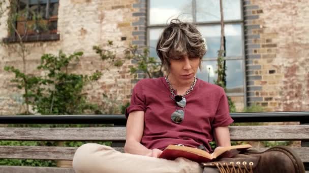 Androgynous Kadın Kitap Okuyor Bankta Oturuyor Rahatlamış Ruh Hali Teknoloji — Stok video
